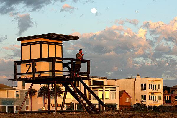 Sunset Beach resident Tom Ellis watches the sunset from a lifeguard tower. Many residents of the beach community object to Orange County's order that it be annexed by its much larger neighbor, Huntington Beach.