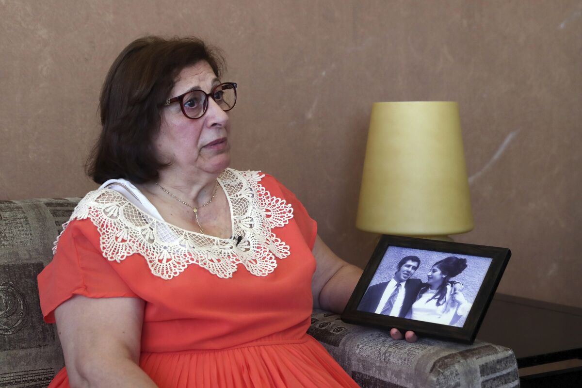 Laure Ghosn, whose husband Charbel Zogheib has been missing for the past 37 years, speaks as she holds their wedding portrait during an interview at her home in Sarba, north of Beirut, Lebanon. Ghosn said her husband is held in Syria and hopes that a new wave of sanctions imposed by the U.S. against the Syrian government will force Damascus to reveal the fate of hundreds of Lebanese citizens held in Syria, including that of her husband. (AP Photo/Bilal Hussein)