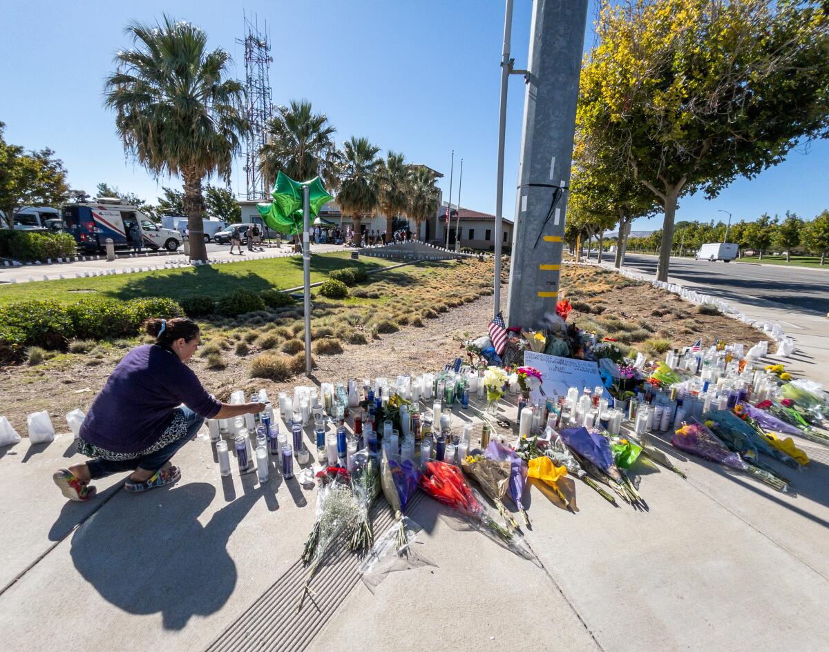 A sidewalk memorial grows at Sierra Highway and Avenue Q in front of the Palmdale Sheriff's Station.