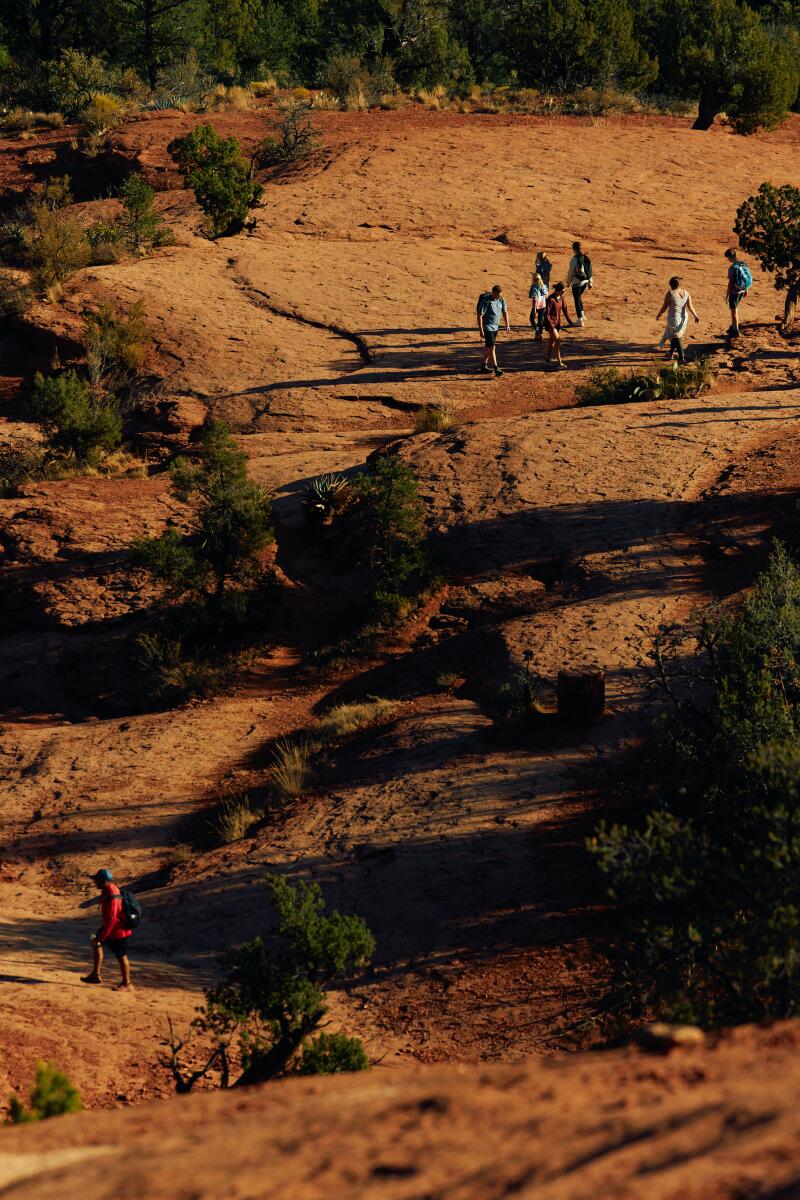 Visitors hike the red rock at Cathedral Rock in Sedona. 