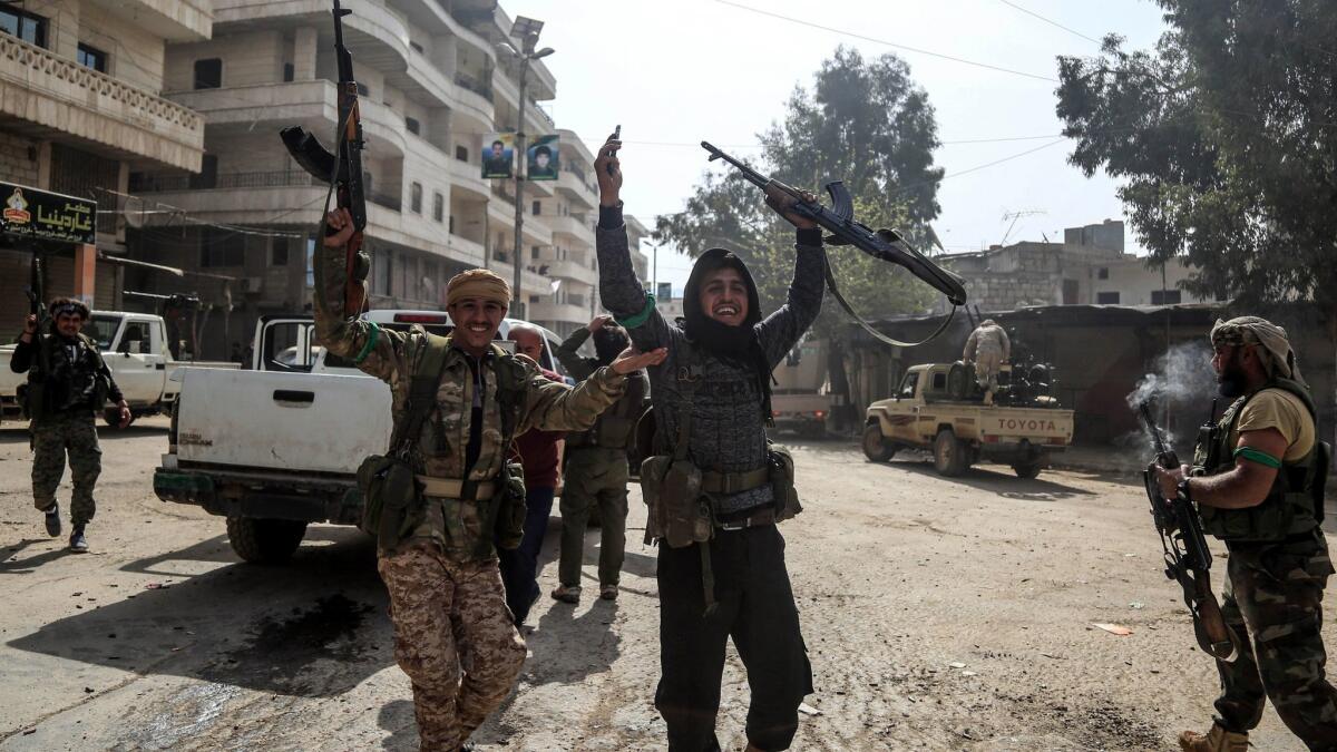 Turkish-backed Free Syrian Army soldiers celebrate after reportedly capturing the city of Afrin in northern Syria.