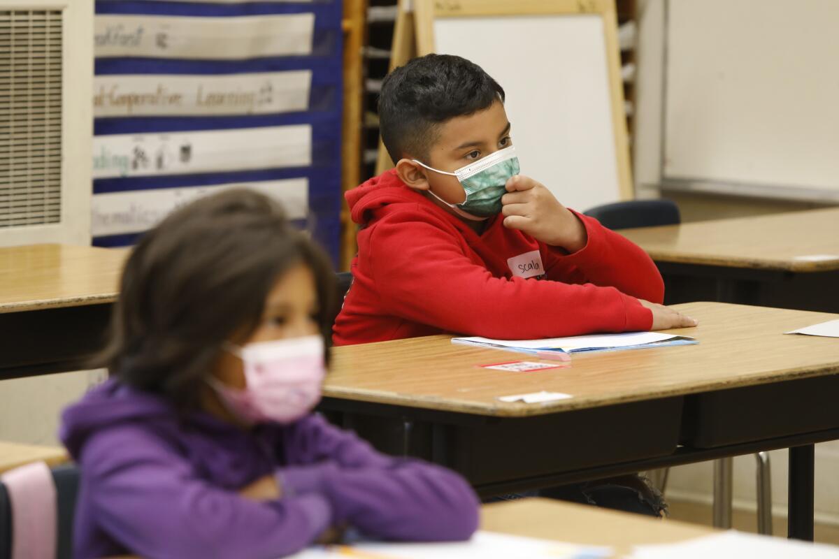 Students wearing masks listen to a teacher at Hooper Avenue School.