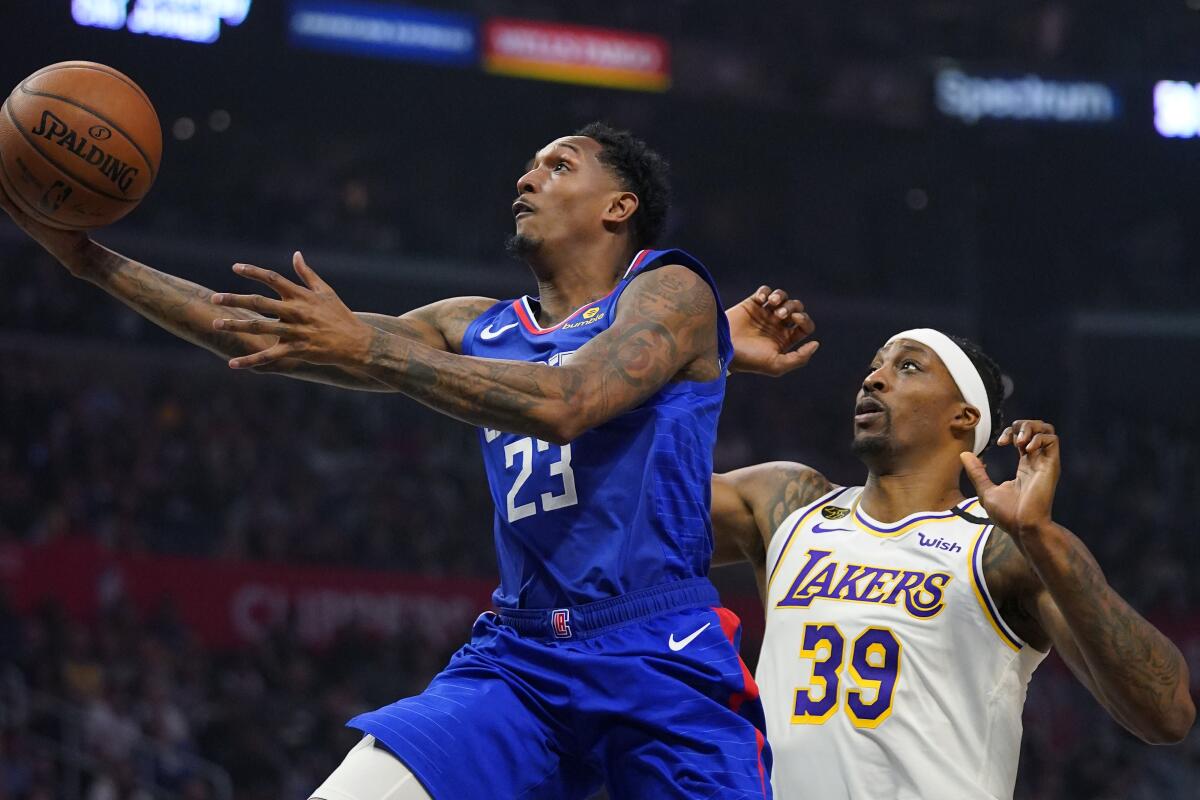 Clippers guard Lou Williams, left, shoots in front of Lakers center Dwight Howard.