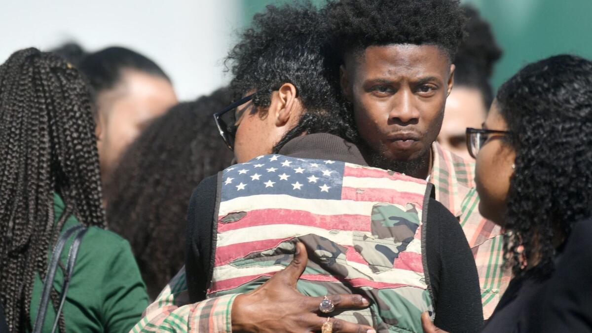 Mourners embrace as they wait to enter Stephon Clark's funeral in Sacramento on March 29.