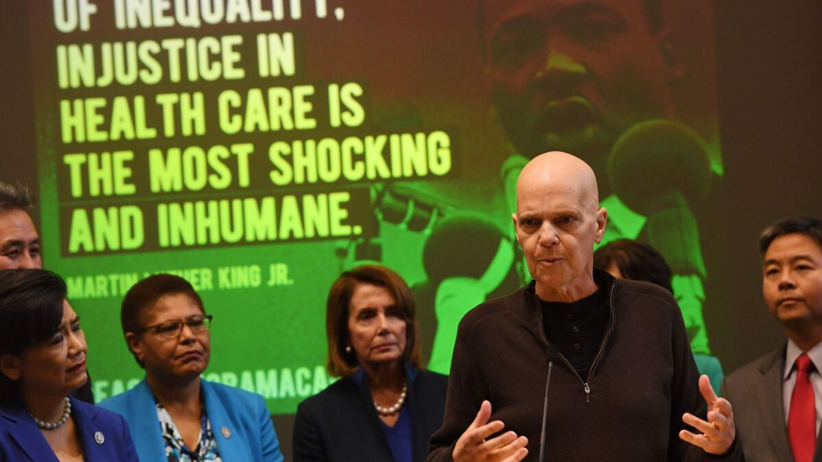 Cancer patient Doug Lunn, who says Obamacare saved his life, speaks beside Nancy Pelosi and House Democrats at an event to protect the Affordable Care Act in downtown L.A. on Jan. 16.