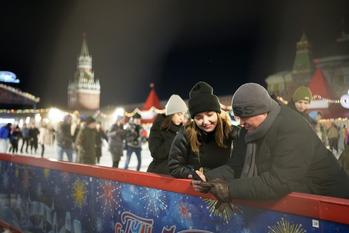 Visitors enjoy the ice rink in Red Square at the Moscow GUM State Department store with the Spasskaya with Tower, left, and the Kremlin Wall in Moscow, Russia, late Monday, Feb. 14, 2022. While the U.S. warns that Russia could invade Ukraine any day, the drumbeat of war is all but unheard in Moscow, where political experts and ordinary people alike don't expect President Vladimir Putin to launch an attack on the ex-Soviet neighbor. (AP Photo/Alexander Zemlianichenko)