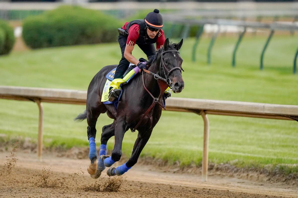 In an April photo, a jockey rides Medina Spirit at Churchill Downs before the Kentucky Derby.