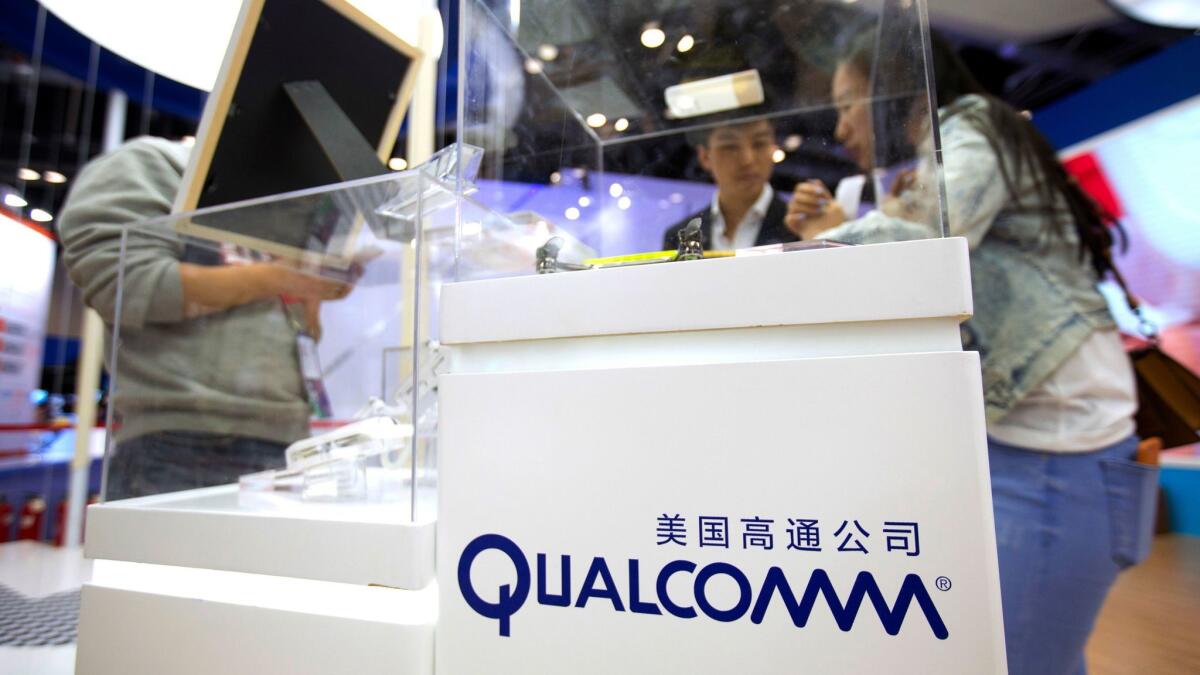 Visitors look at a display booth for Qualcomm at the Global Mobile Internet Conference in Beijing last April.