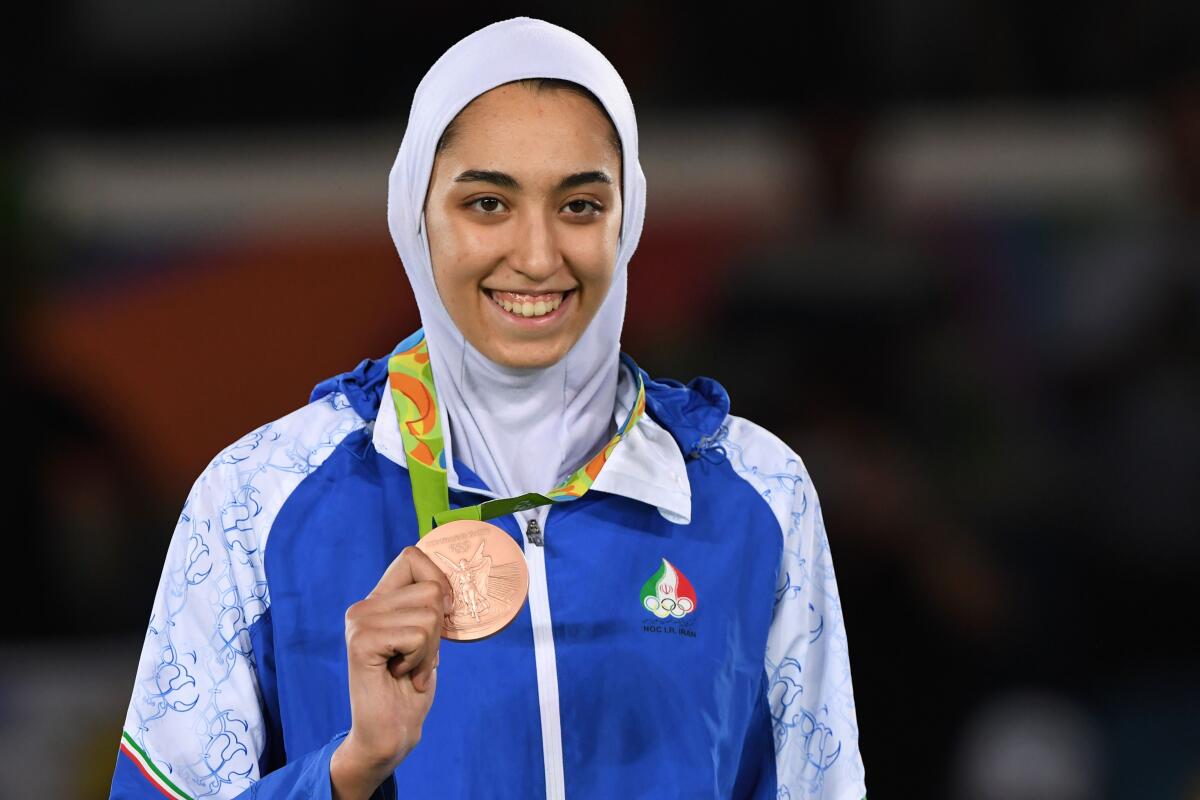 Iran's Kimia Alizadeh poses on the podium after winning a bronze medal in taekwondo at the Rio de Janeiro 2016 Olympic Games.