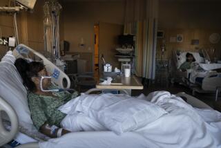Natalie Balli, 71, and her twin sister, Linda Calderon, background right, watch TV as they rest in their beds in a COVID-19 unit at Providence Holy Cross Medical Center in Los Angeles, Friday, Dec. 17, 2021. The sisters were admitted to the hospital on the same day, a few days after their Thanksgiving gathering. (AP Photo/Jae C. Hong)