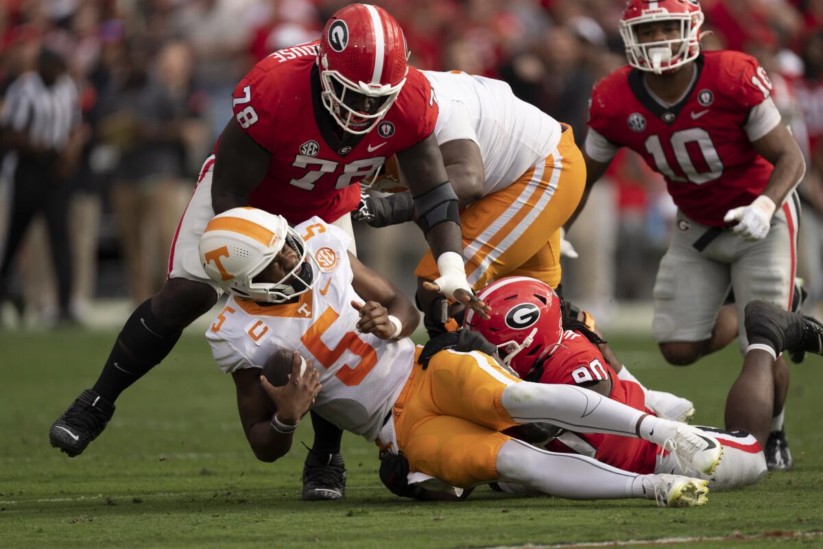 Tennessee's Hendon Hooker is brought down by Georgia's Tramel Walthour (90) and Nazir Stackhouse (78) on Nov. 5, 2022.