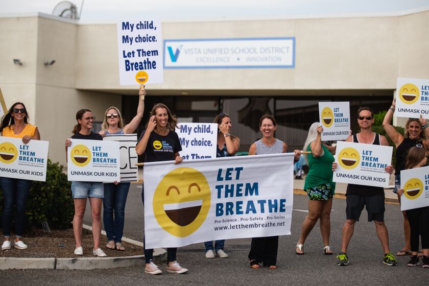 Parents hold signs protesting against the requirement of face masks in school at the Vista Unified School District on Thursday, July 22, 2021. Sharon McKeeman (center, holding the banner) is the founder of Let Them Breathe.