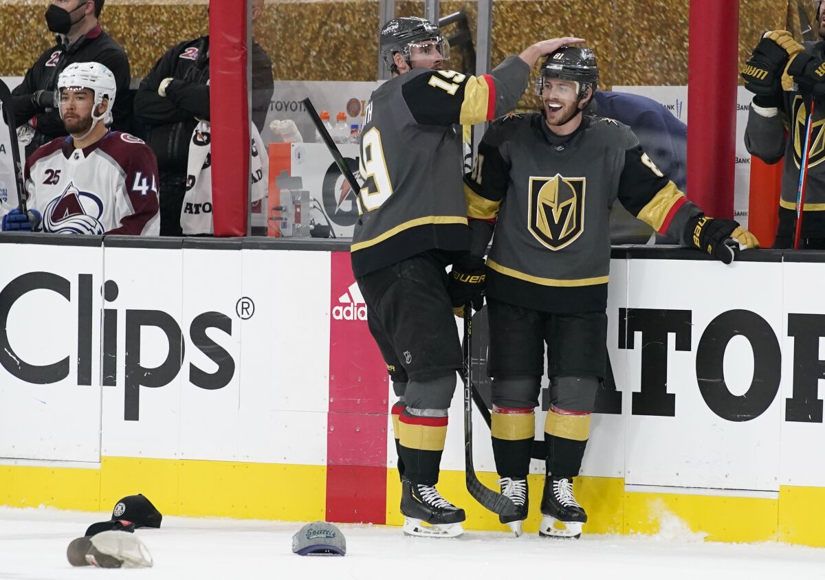 Vegas Golden Knights right wing Reilly Smith (19) celebrates after Vegas Golden Knights center Jonathan Marchessault, right, scored his third goal against the Colorado Avalanche during the third period in Game 4 of an NHL hockey Stanley Cup second-round playoff series Sunday, June 6, 2021, in Las Vegas. (AP Photo/John Locher)