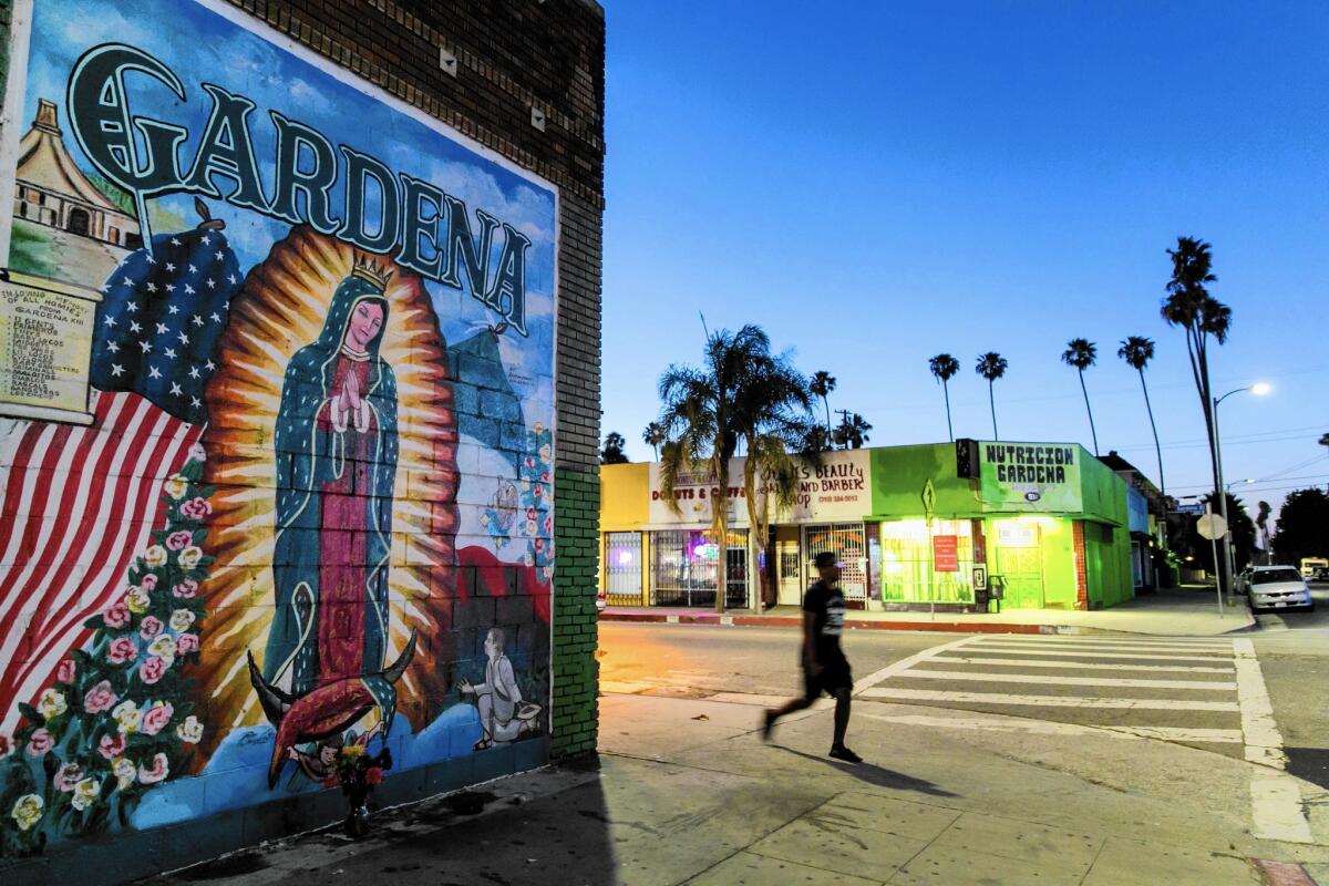 A man walks past a mural in Gardena. Over the past five years in L.A. County, data show that Latinos have consistently represented about half of the people killed by police. But the deaths rarely stoke large public demonstrations.