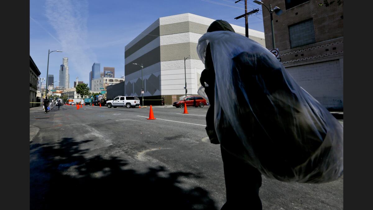 A homeless man walks along 5th Street in downtown Los Angeles with his possessions on his back after a cleanup program on skid row.
