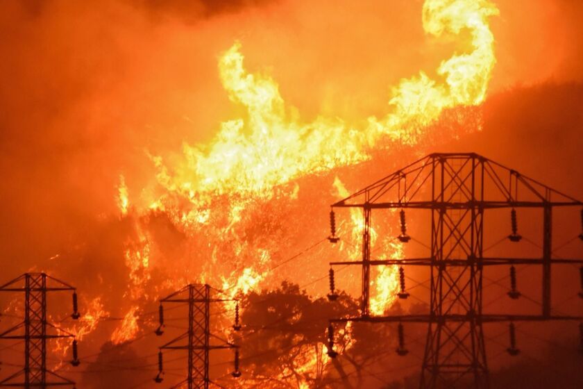 In this Dec. 16, 2017, photo provided by the Santa Barbara County Fire Department, flames burn near power lines in Sycamore Canyon near West Mountain Drive in Montecito, Calif. The huge wildfire that burned hundreds of homes in Santa Barbara and Ventura counties is now the largest in California's recorded history. State fire officials said Friday, Dec. 22, 2017, that the Thomas fire has scorched 273,400 acres, or about 427 square miles of coastal foothills and national forest. That was 154 acres larger than the 2003 Cedar fire in San Diego that killed 15 people. Thousands of firefighters and fleets of aircraft have been battling the blaze since Dec. 4. A firefighter and a woman fleeing the blaze died. (Mike Eliason/Santa Barbara County Fire Department via AP)