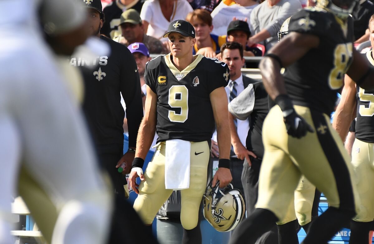 With his thumb wrapped, Saints quarterback Drew Brees watches from the sideline at the Coliseum on Sunday. 