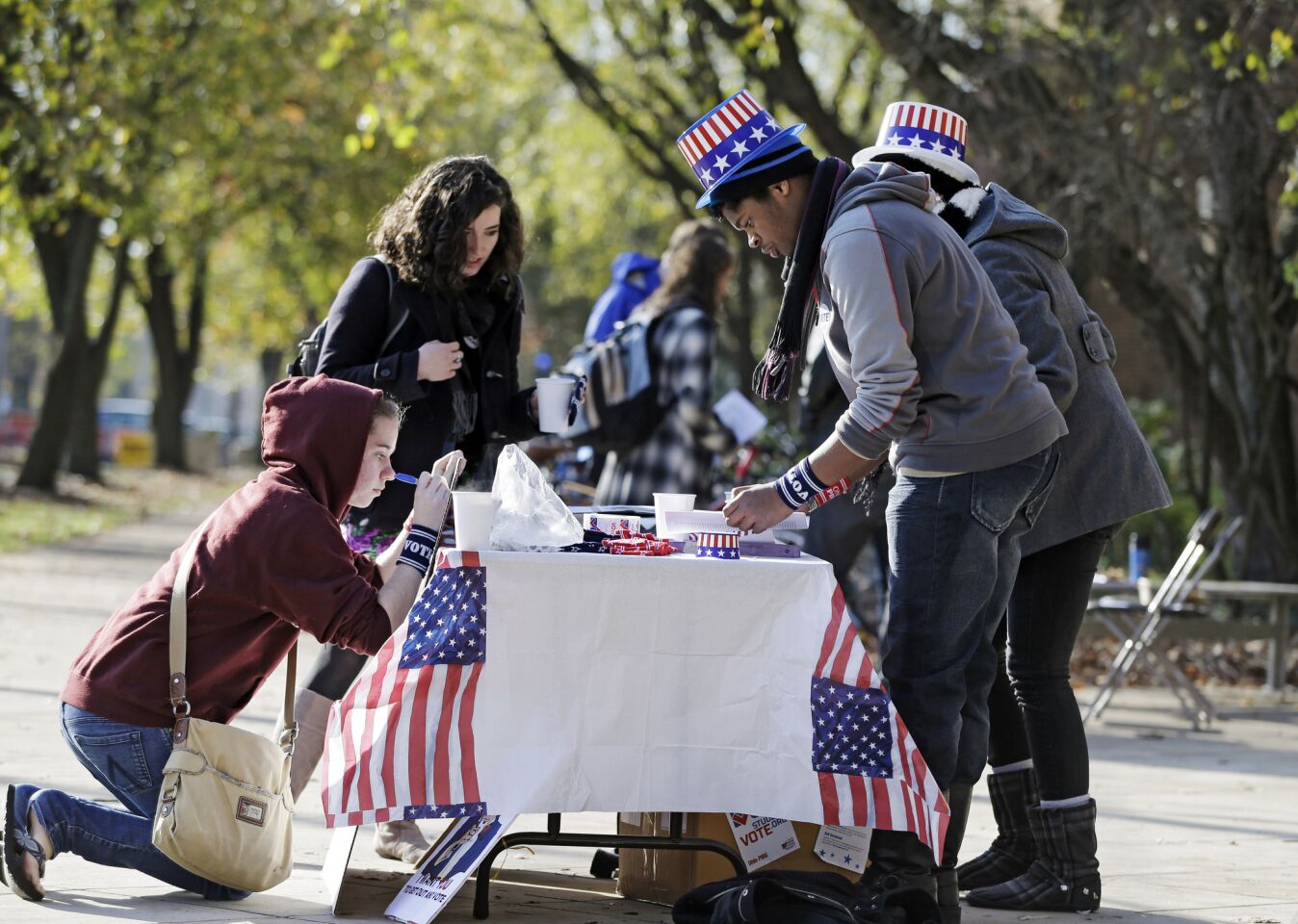 Classical studies major Omar Dyette, front right, mans a table outside the polls on the campus of Oberlin College in Oberlin, Ohio.