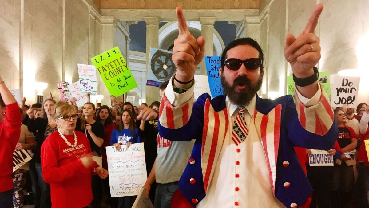 Parry Casto, a fifth-grade teacher at the Explorer Academy in Huntington, W.Va., dressed in an Uncle Sam costume, leads hundreds of teachers in chants March 1 at the Capitol in Charleston.