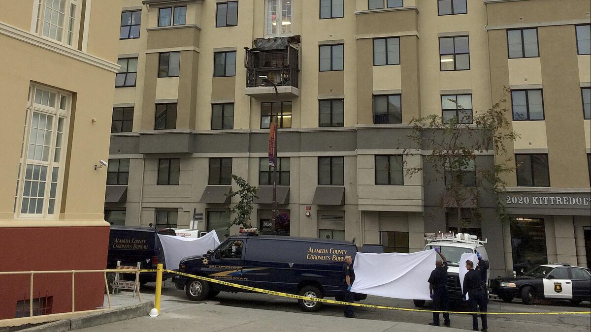 Makeshift curtains are held up to shield the removal of bodies at the Library Gardens apartments in Berkeley after a fifth-floor balcony collapsed, killing six and injuring seven.
