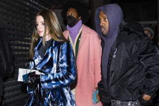 Julia Fox and Kanye West walk with a man behind them