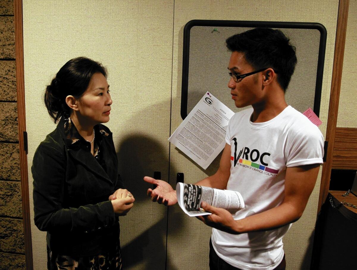 Hieu Nguyen, right, a founding member of the gay rights group Viet Rainbow of Orange County, speaks with Garden Grove Mayor Pro Tem Dina Nguyen during a break in a City Council meeting in September. Hieu's group has emerged as a militant front and a platform for educating immigrants in Little Saigon, a community that rigidly clings to tradition.
