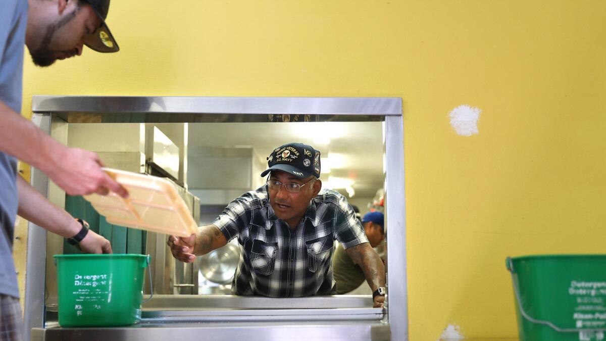 U.S. Navy veteran Martin Martinez, 52, center, works in the kitchen at the Salvation Army's Bell homeless shelter, where he has lived for four months.