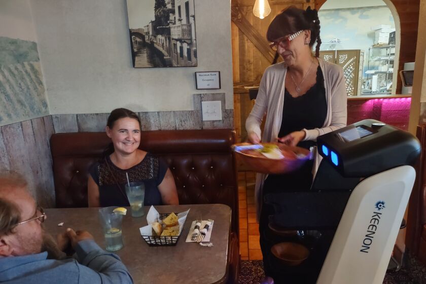 Mamma Ramona's Lead Server Lysa Horgan, right, serves food off Rosie’s shelves to Melanie Van Doren and Benjamin Spilman.