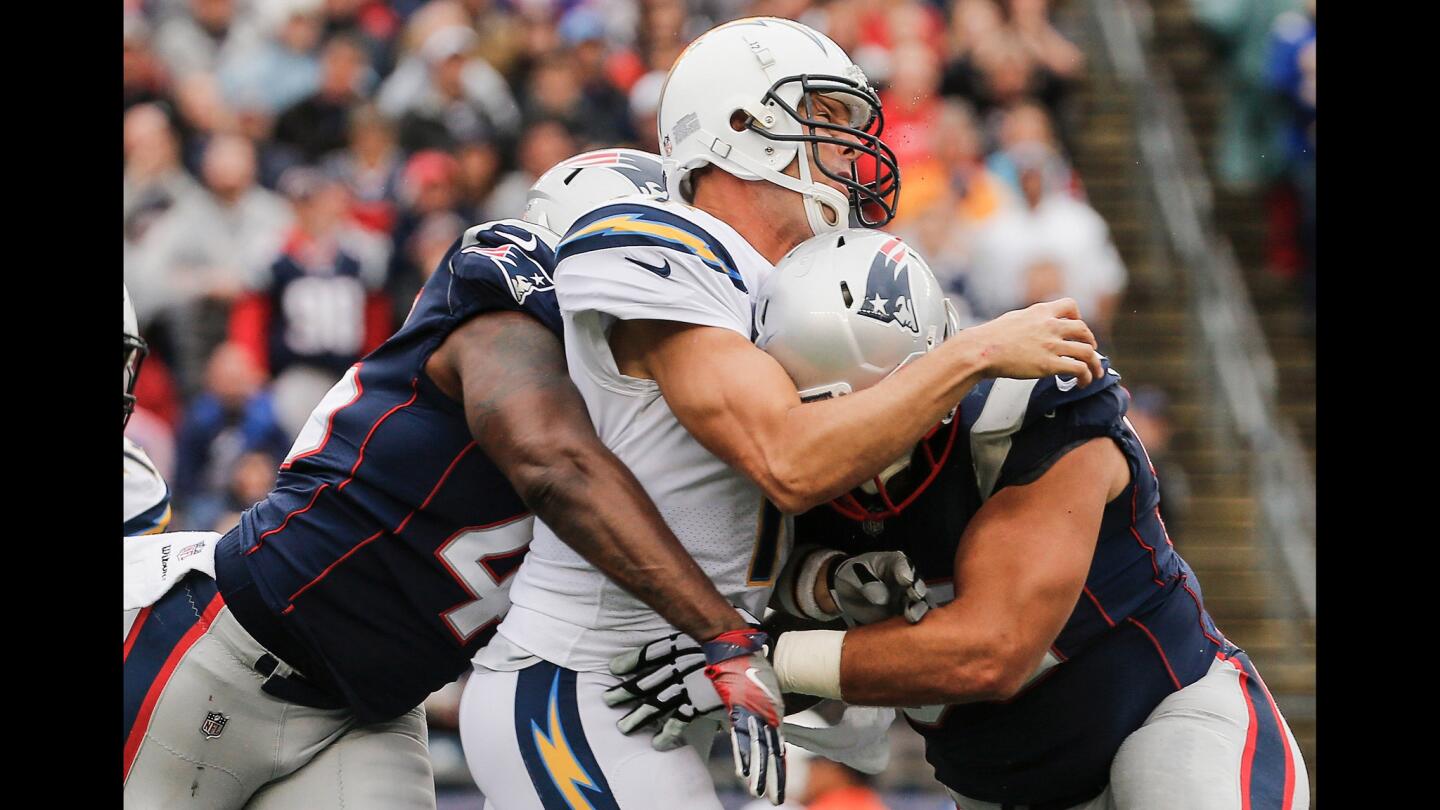 The Patriots' David Harris and Lawrence Guy wrap up Chargers quarterback Philip Rivers in the fourth quarter.