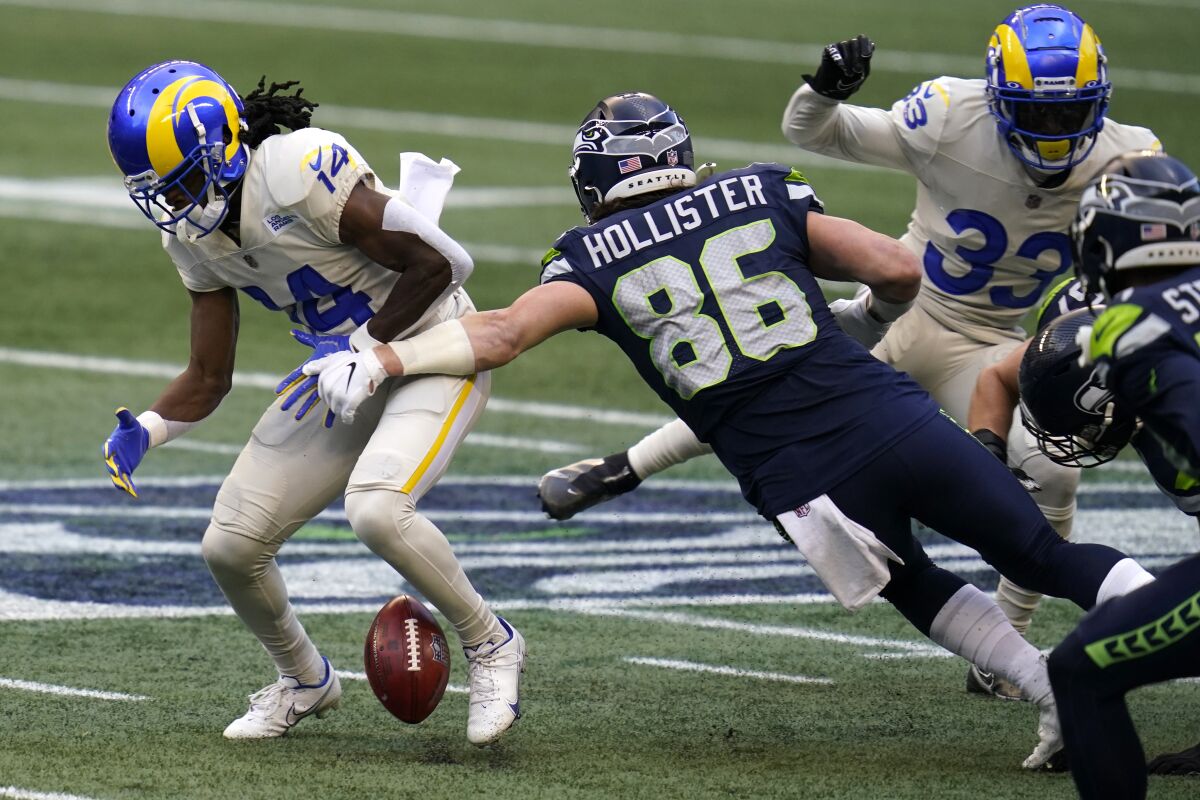 Seattle Seahawks tight end Jacob Hollister forces a fumble by the Rams' Nsimba Webster.