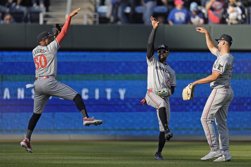 Willi Castro (50), Byron Buxton, centro, y Matt Wallner, de los Mellizos de Minnesota, celebran después de su partido de béisbol contra los Reales de Kansas City, el jueves 28 de marzo de 2024, en Kansas City, Missouri. Los Mellizos ganaron 4-1. (AP Foto/Charlie Riedel)