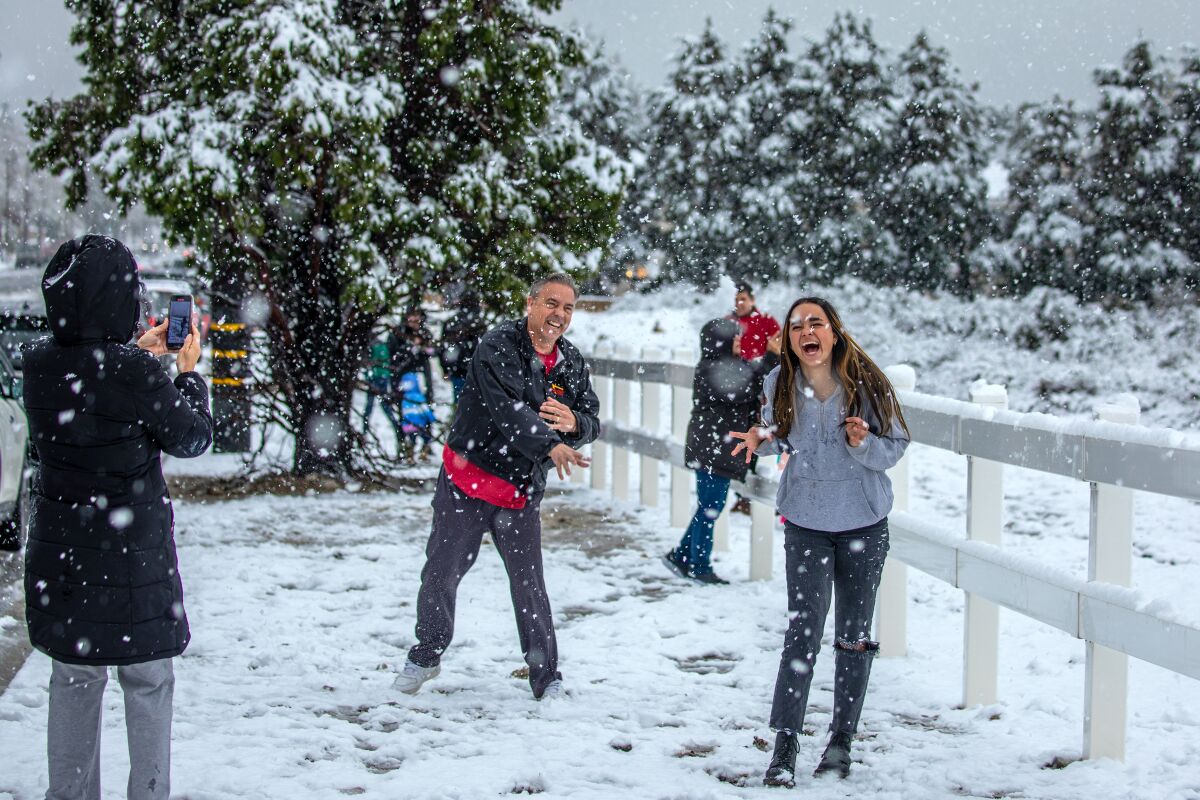 People smile as they enjoy the falling snow