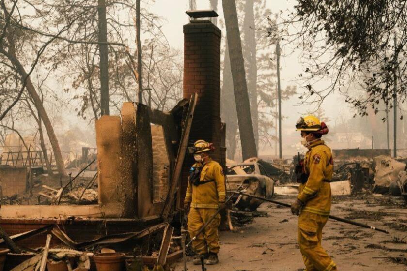 Cal Fire crews walk through the rubble of home putting hotspots in Paradise Calif. on Saturday, Nov. 10, 2018. (Mason Trinca for The Los Angeles Times)