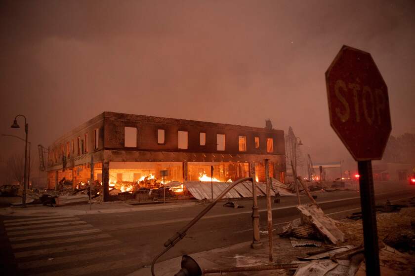 TOPSHOT - Buildings smolder as the Dixifire rips through downtown Greenville, California on August 4, 2021. - The Dixie fire burned through dozens of homes and businesses in downtown Greenville and continues to forge towards other residential communities. Officials in northern California on August 4, 2021 warned residents of two communities in the path of the raging Dixie fire to evacuate immediately as high winds whipped the flames onwards. (Photo by JOSH EDELSON / AFP) (Photo by JOSH EDELSON/AFP via Getty Images)