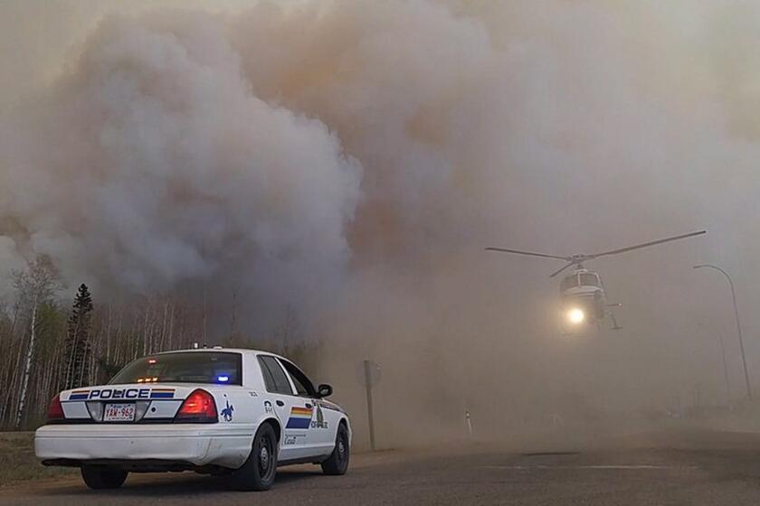 Royal Canadian Mounted Police officers carry out rescue and evacuation work near Fort McMurray.