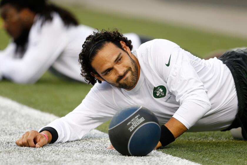 New York Jets quarterback Mark Sanchez stretches before Thursday's game against the New England Patriots.