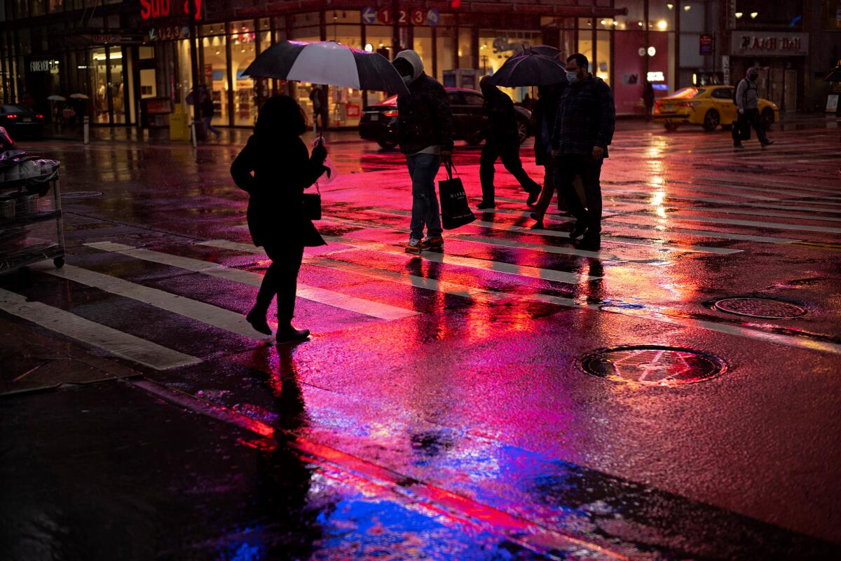 Shoppers walk in a rainstorm.