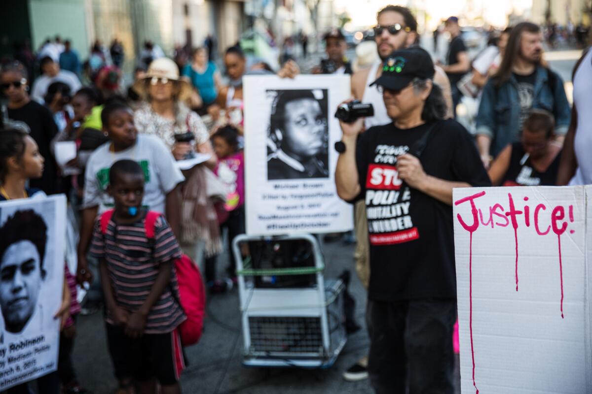Protesters against police violence stop at the site where Charly "Africa" Keunang was killed on skid row in 2015.