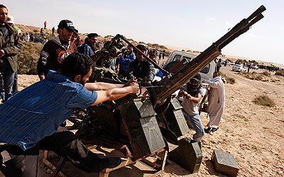 Rebel fighters prepare to fire an antiaircraft gun against forces loyal to Moammar Kadafi in Port Brega.