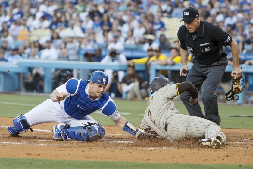 Penangkap Dodgers Will Smith menandai Trent Grisham dari San Diego di home plate.