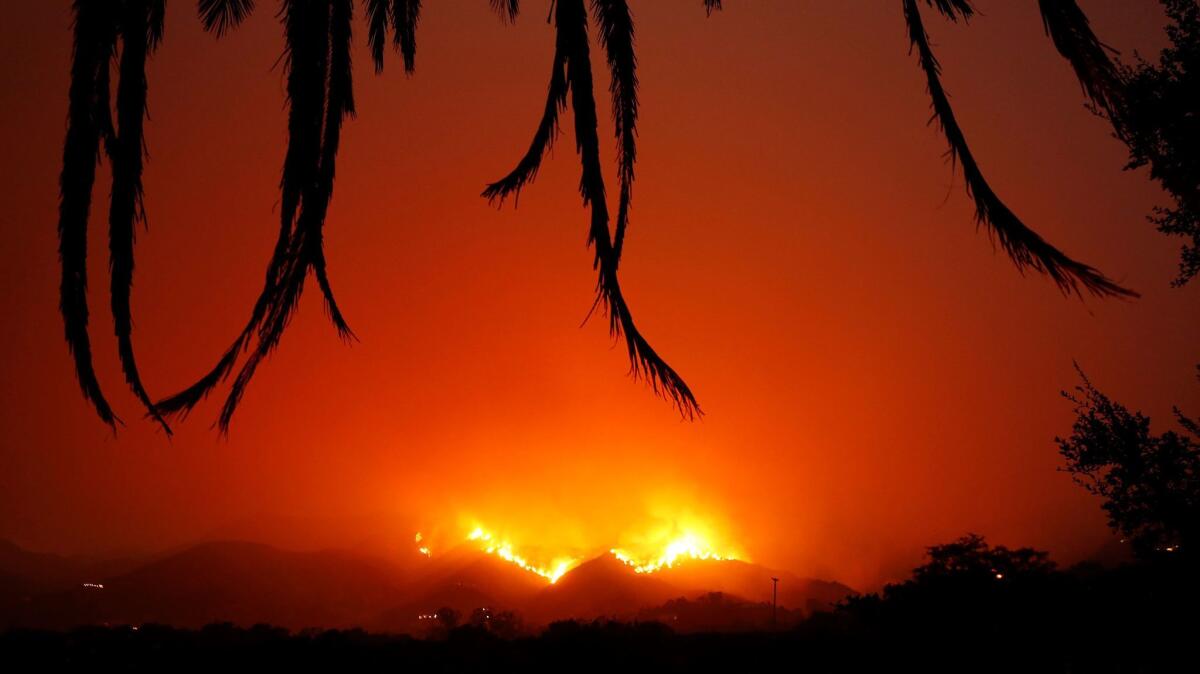 Fire burns back down the hill behind East Valley Road by Ladera Lane near Toro Canyon in Montecito at dusk Tuesday.