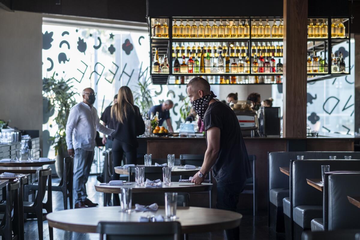 A man stands at a table at a restaurant
