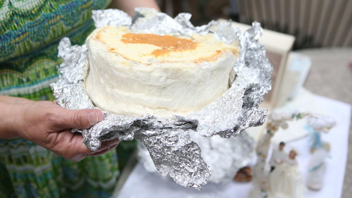 Mary Caldwell unwraps what's left of her wedding cake from June 8, 1968, which is still frozen in her Newport Beach home.