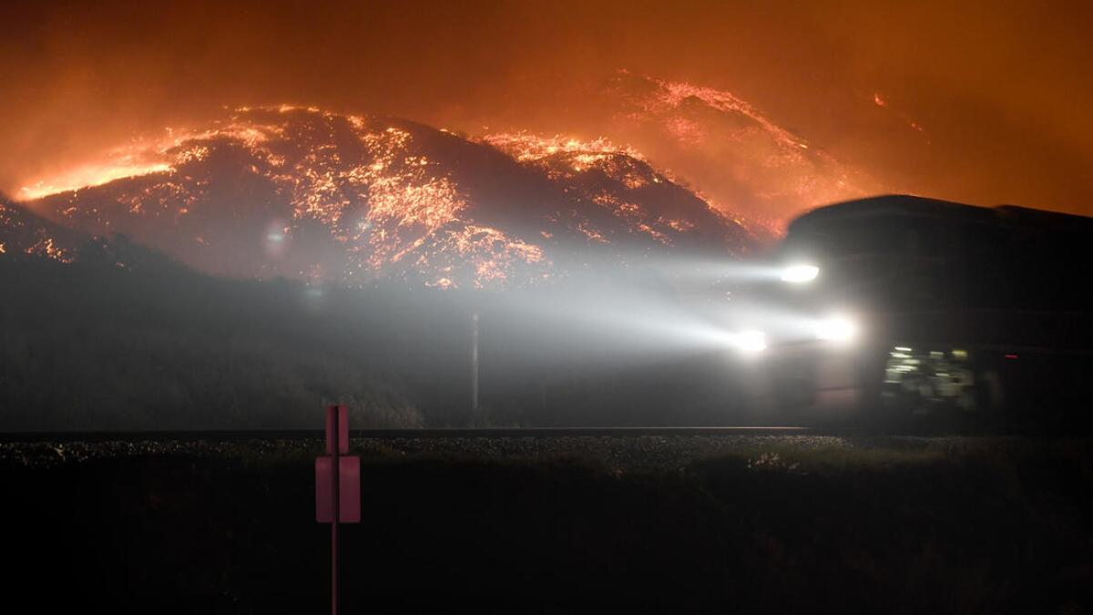 A train on the Rincon coast passes a burning hillside from the Thomas fire.