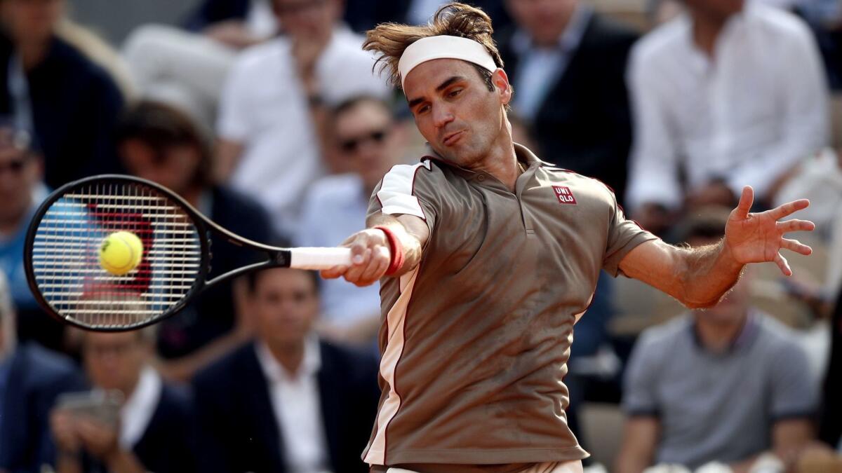 Roger Federer returns a forehand shot against Stan Wawrinka during a French Open quarterfinal on Tuesday.
