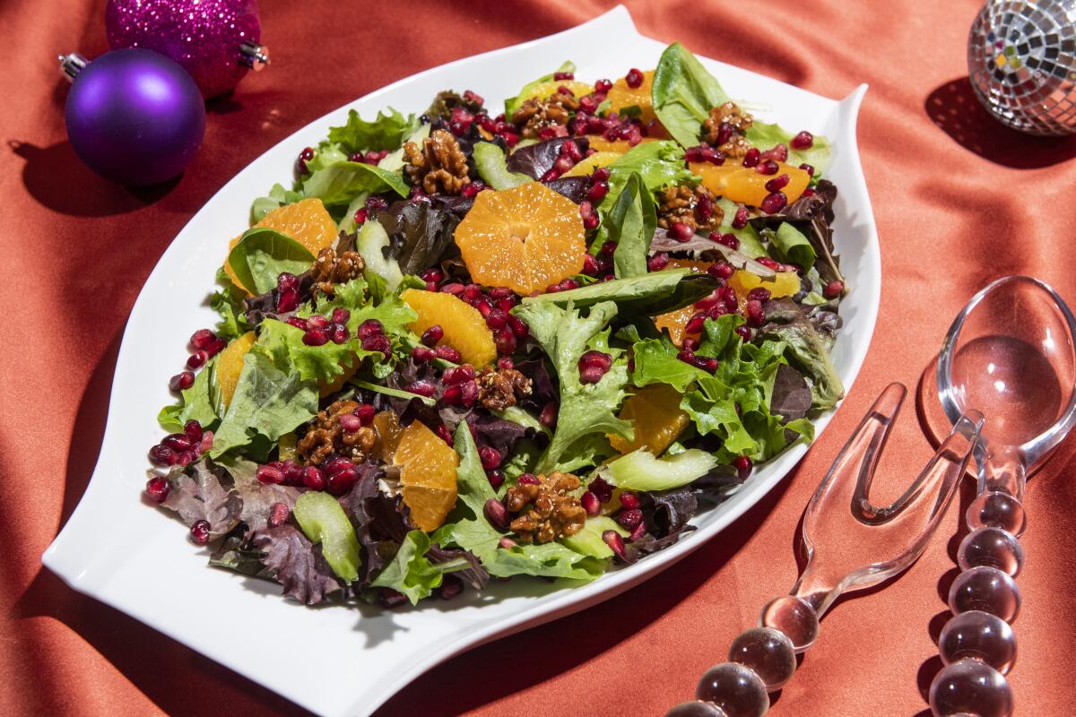 A mix of citrus and pomegranate seeds adds bright colors and flavors to this simple mixed green salad.