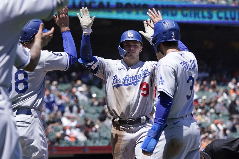 Los Angeles Dodgers' Gavin Lux, center, is congratulated by DJ Peters, left, and, Chris Taylor.