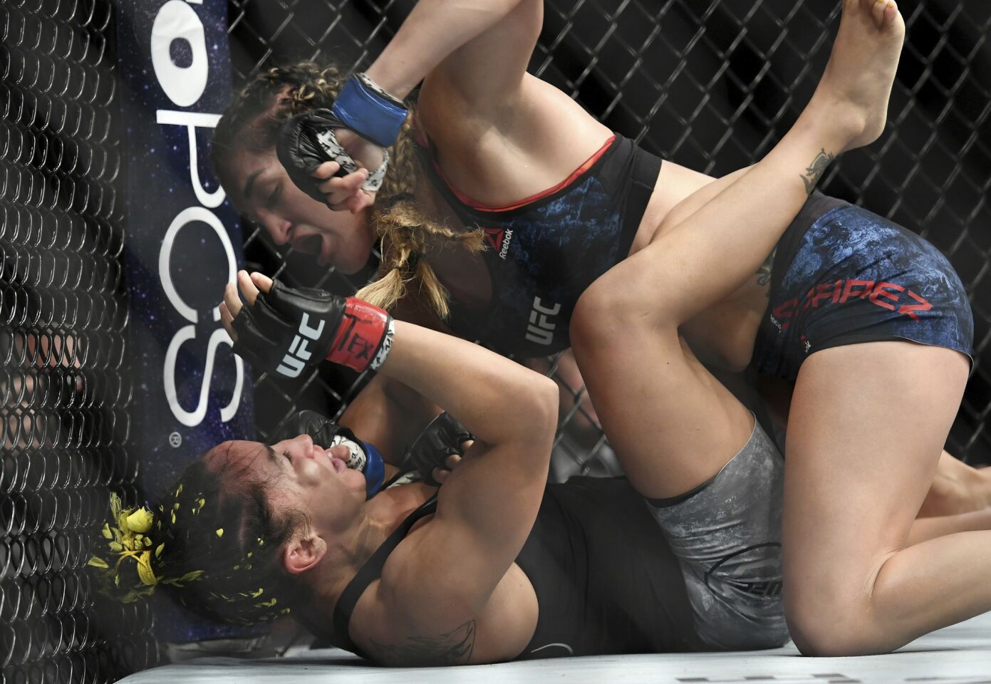 Tatiana Suarez, top, punches Carla Esparza during their strawweight mixed martial arts bout at UFC 228 on Saturday, Sept. 8, 2018, in Dallas. (AP Photo/Jeffrey McWhorter)