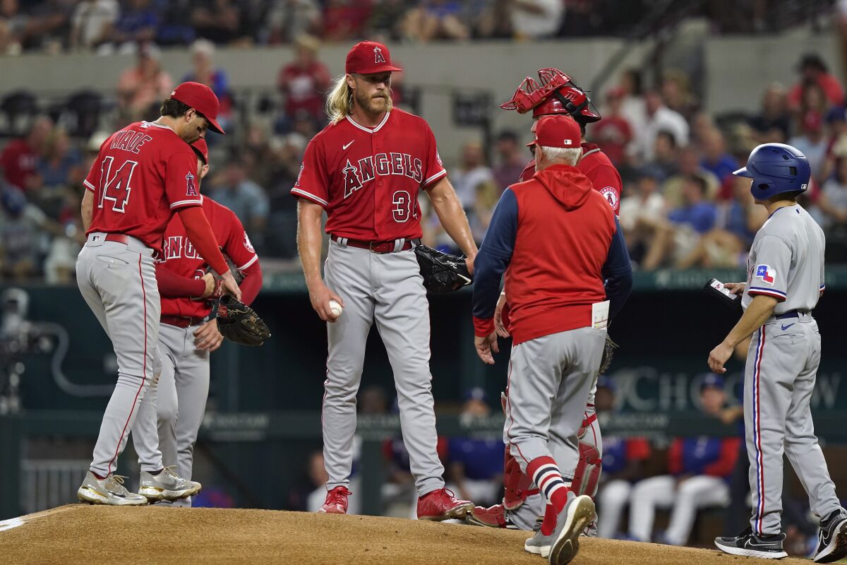 Angels pitcher Noah Syndergaard stands on the mound with teammates as manager Joe Maddon heads out to make a pitching change.
