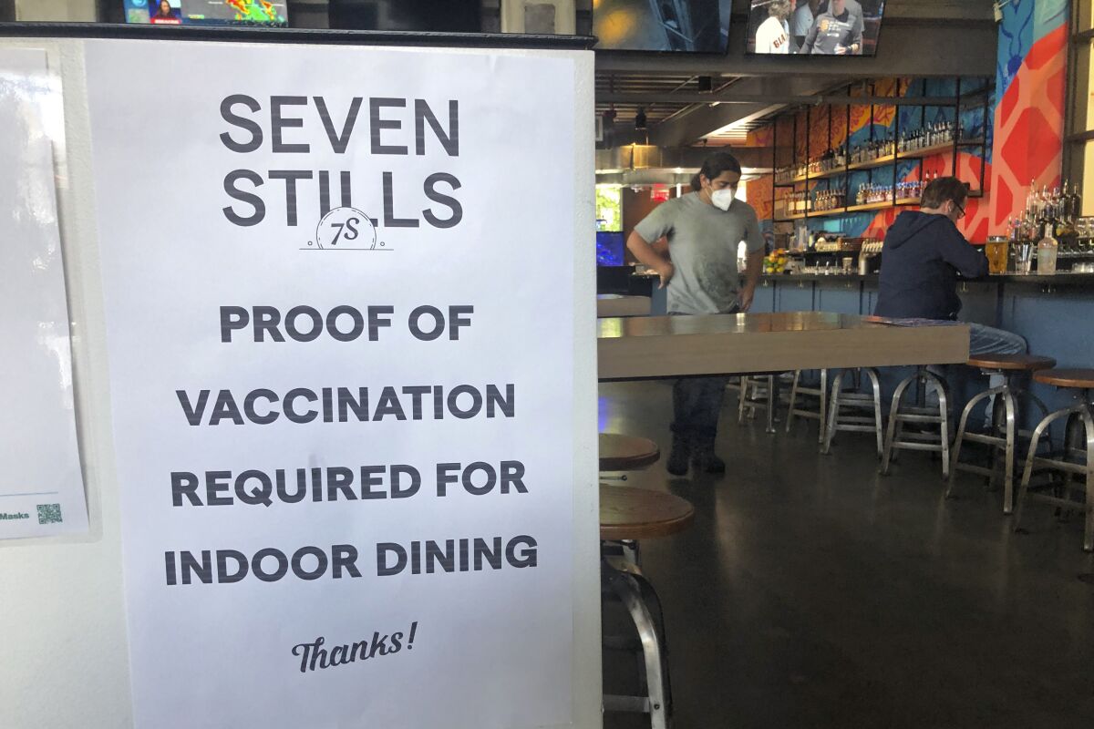A proof of vaccination sign is posted at a bar in San Francisco on Thursday, July 29, 2021. Until now, many employers had taken a passive approach to their unvaccinated workers, relying outreach and incentives. But that has been shifting, with vaccine mandates gaining momentum. (AP Photo/Haven Daley)